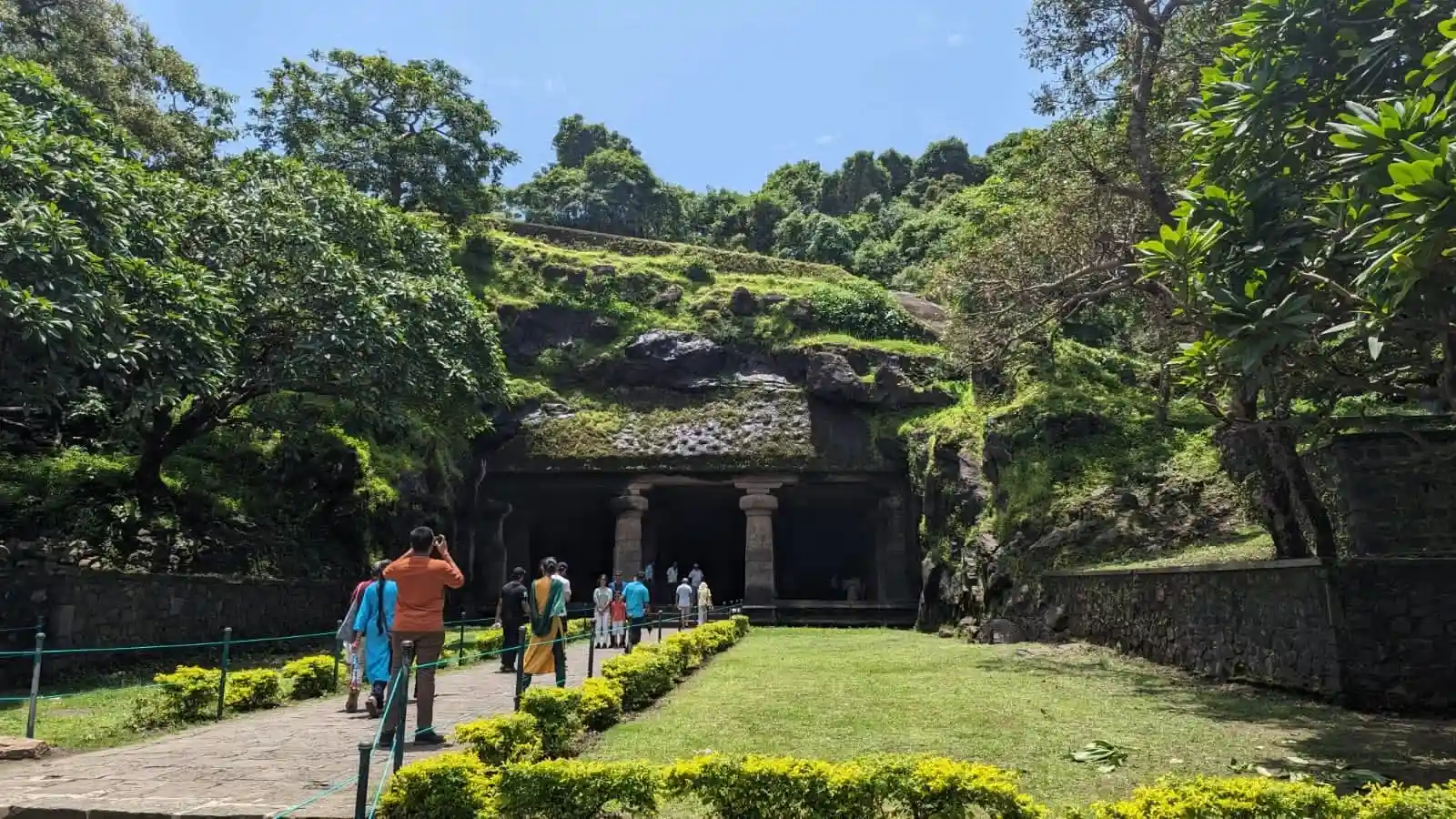 Visitors approaching the ancient Elephanta temple entrance through the beautifully green grounds of Elephanta Island on a private Elephanta Caves tour from Mumbai
