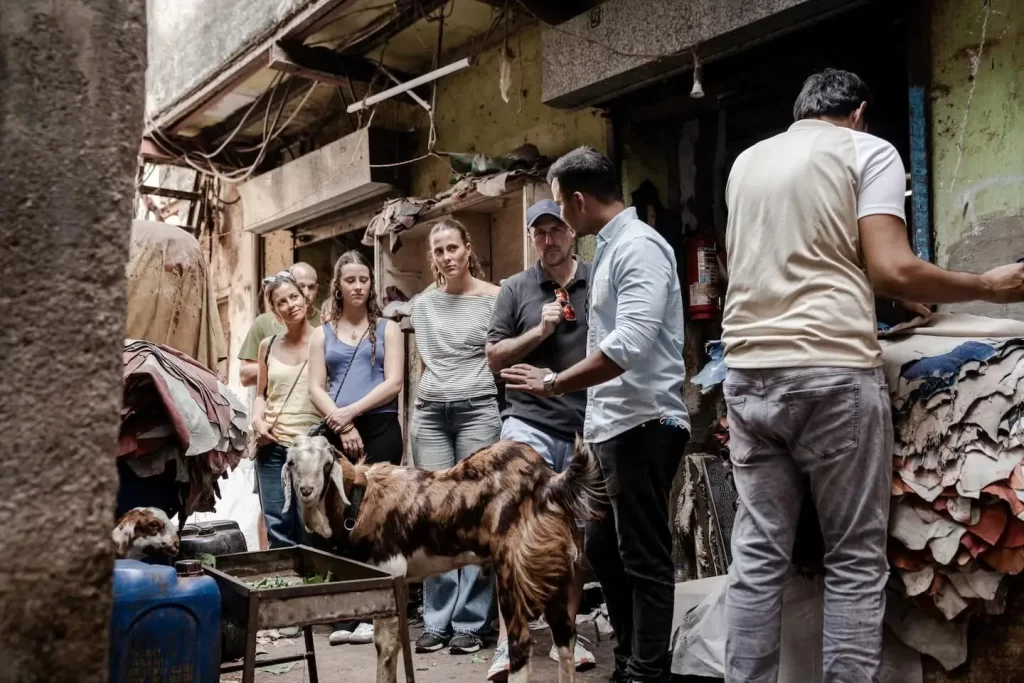 Tour group listening to a local guide at the Dharavi slum leather workshop on a Dharavi local tour by Cityscape Mumbai Tours