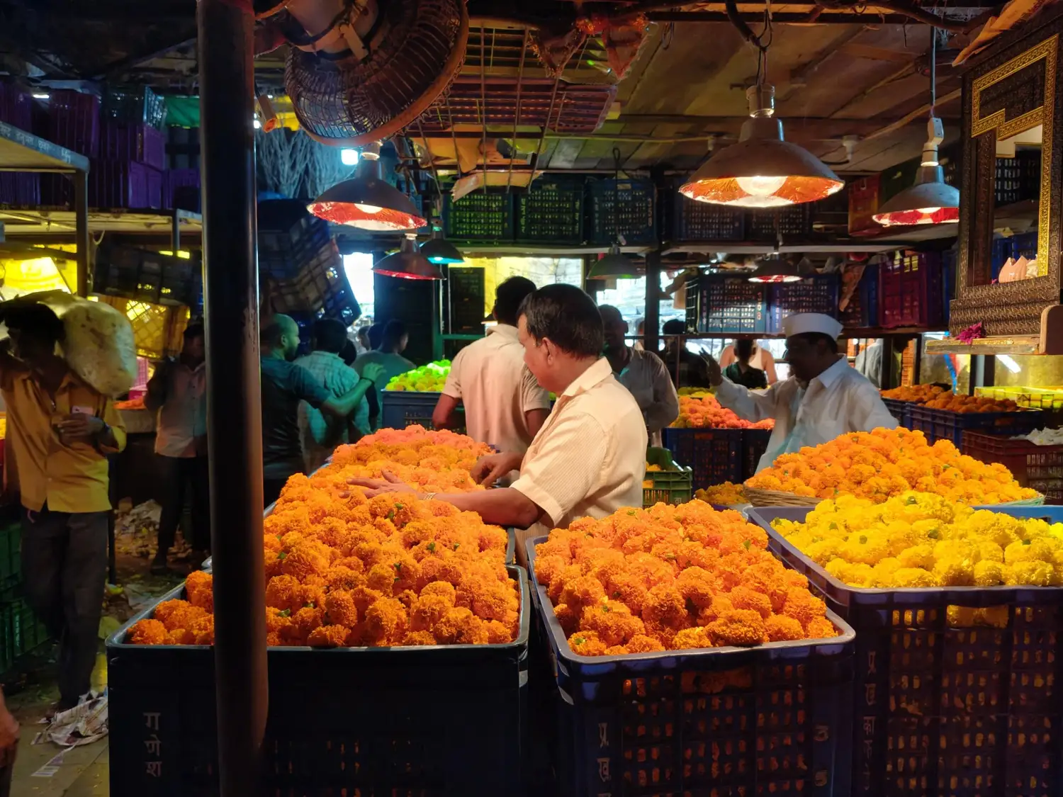 Vendors sorting fresh marigold crates inside Dadar Flower Market.