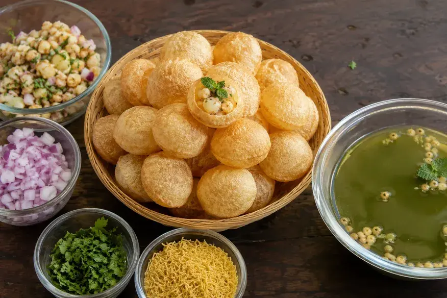 Crispy Pani Puri with stuffing, mint-spiced water, onions, coriander and sev served in bowls - Cityscape Mumbai Tours food guide