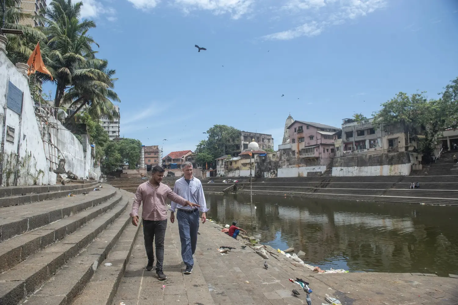 Our local guide is taking a cruise passenger through the historic Banganga Tank area during a private Mumbai Shore Excursion with Cityscape Mumbai Tours.