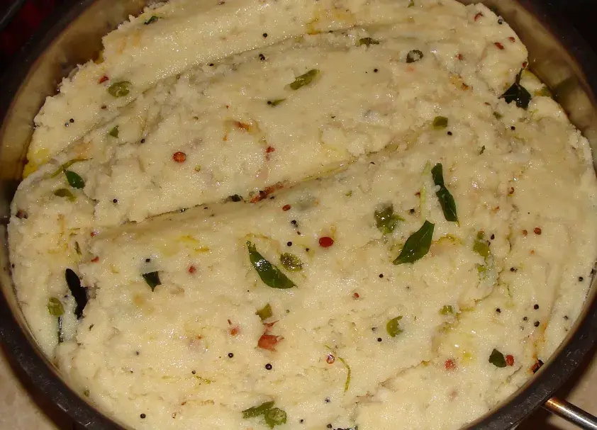 Soft semolina Upma garnished with mustard seeds, curry leaves and coriander, served in a pan - Cityscape Mumbai Tours food guide