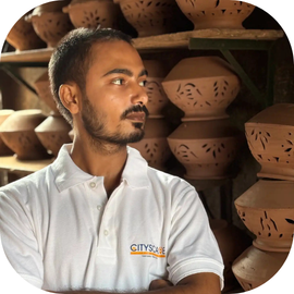 Cityscape Mumbai Tours, Abhishek Kanhojiya, Social Media Manager, standing among rows of clay pots in Dharavi's Kumbharwada pottery quarter