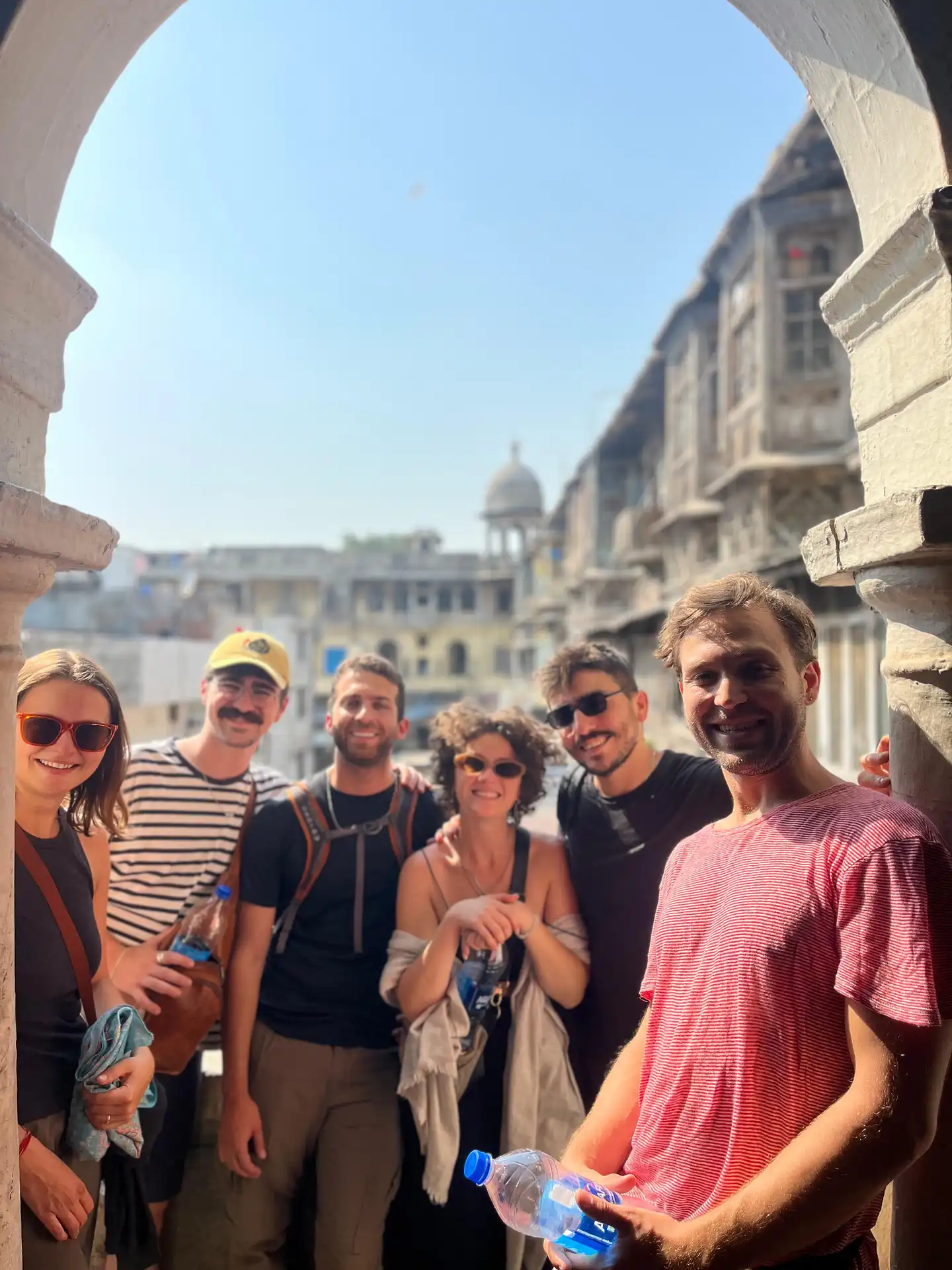 Framed by an old stone archway, our group takes in the rooftop view over Chandni Chowk during this old delhi sightseeing walk