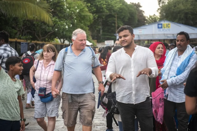 Cityscape Mumbai Tours guide leading foreign travelers on a walking tour through a busy Mumbai street during a Mumbai travel agency city tour.
